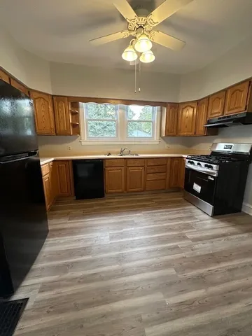a large kitchen with kitchen island granite countertop a sink stainless steel appliances and cabinets