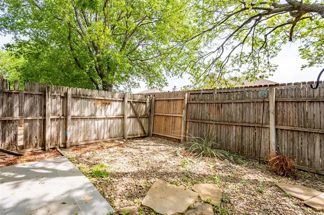 a view of a backyard with wooden fence