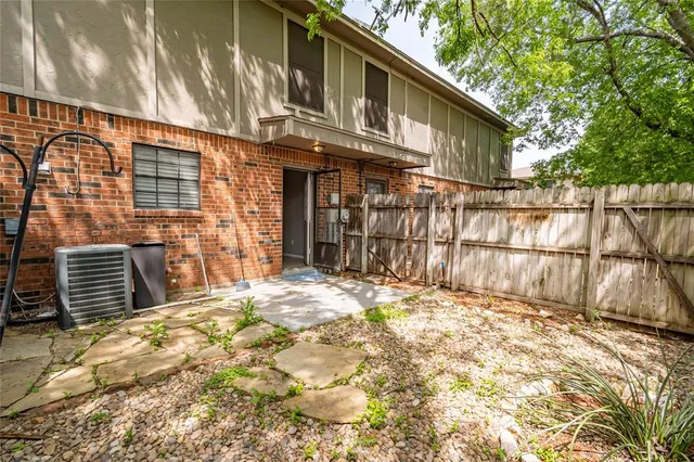 a view of a backyard with wooden fence and large windows