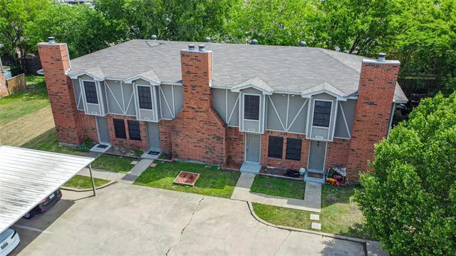 an aerial view of a house with yard and green space