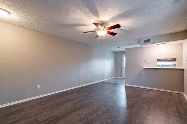 a view of a room with wooden floor and a ceiling fan