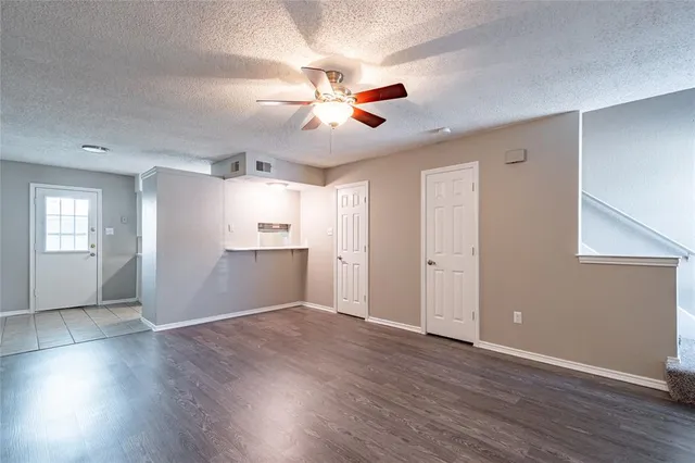 a view of an empty room with window and wooden floor
