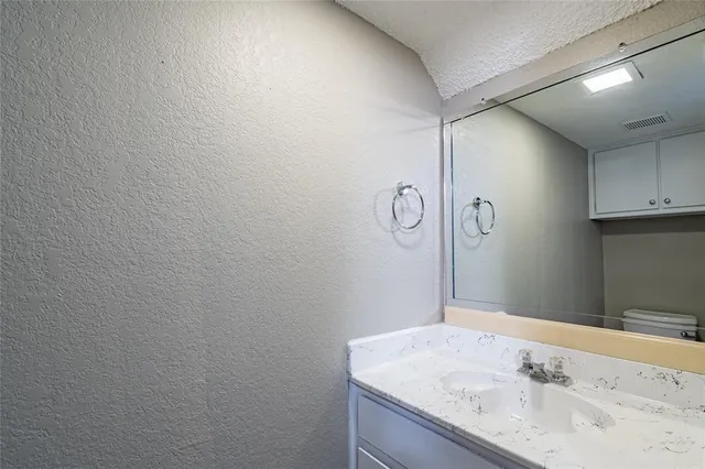 a bathroom with a granite countertop sink and a mirror