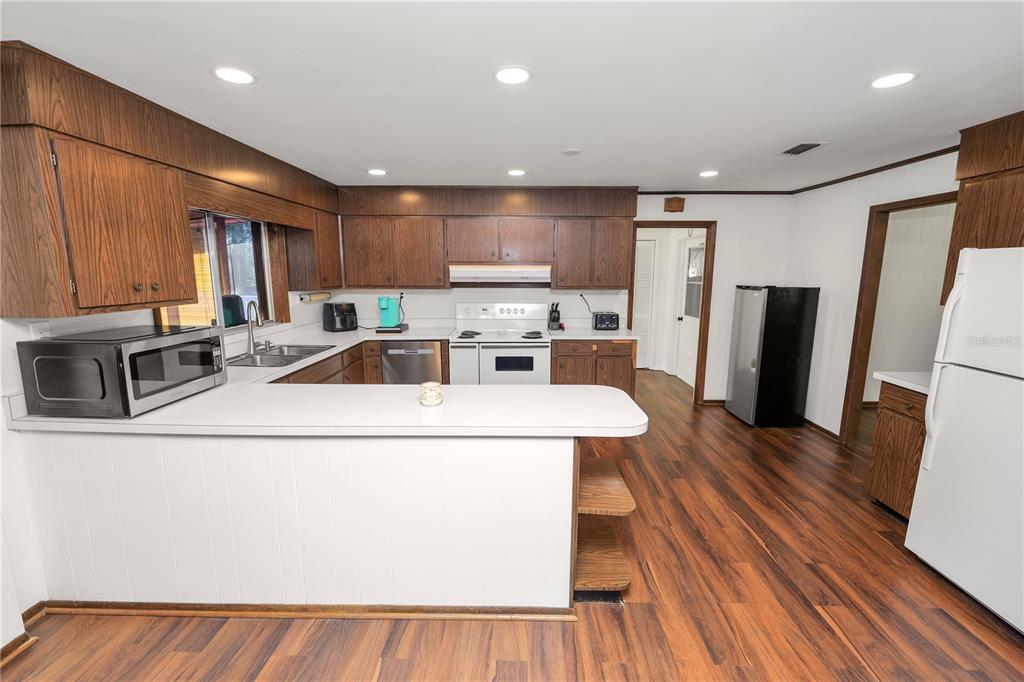 4615 Old Polk City Road Lakeland, FL 33809 - Photo 13 of 71 a kitchen with stainless steel appliances a refrigerator a sink a stove a microwave and cabinets