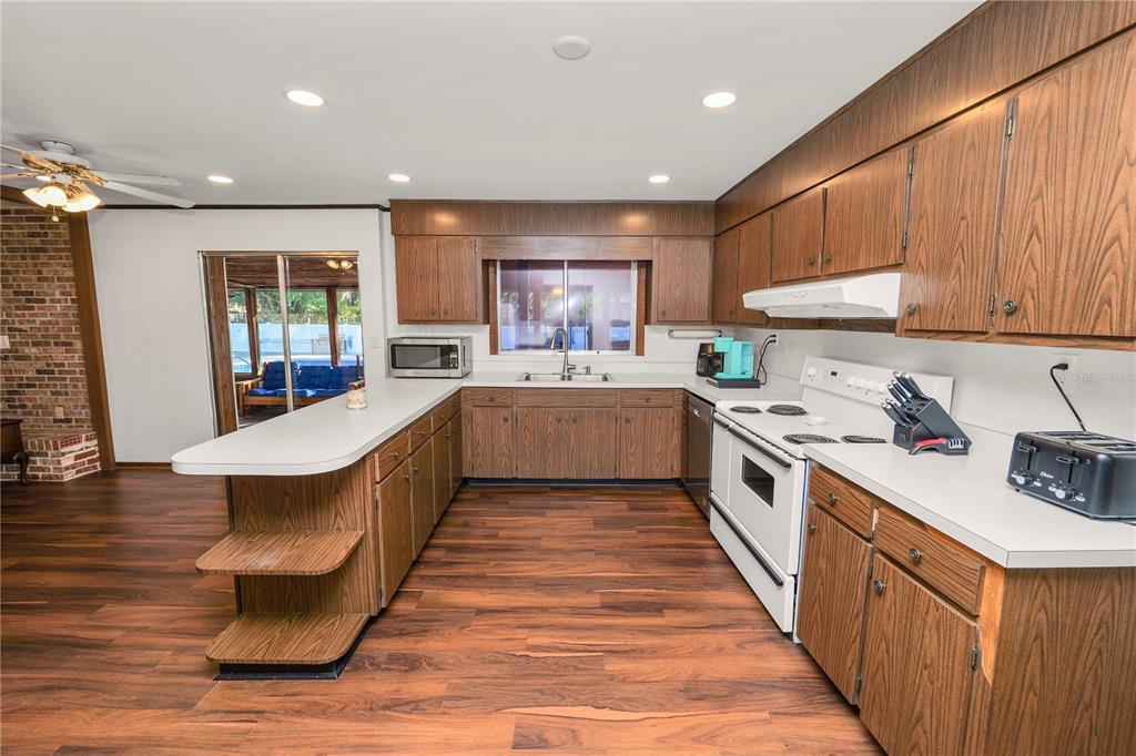 4615 Old Polk City Road Lakeland, FL 33809 - Photo 16 of 71 a large kitchen with stainless steel appliances kitchen island granite countertop a sink and cabinets