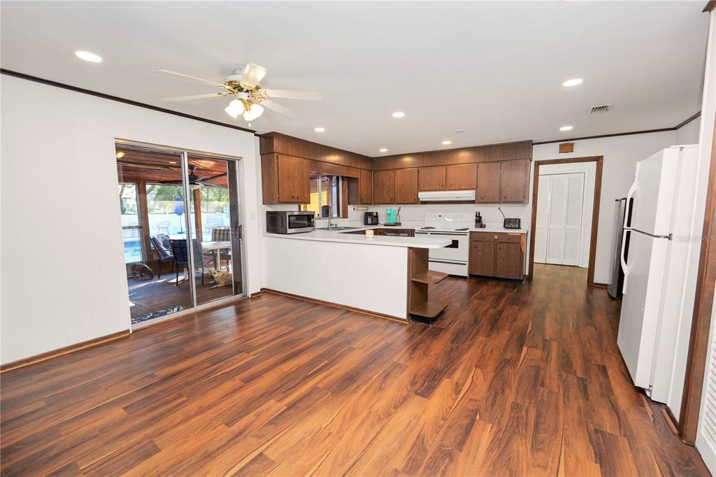 4615 Old Polk City Road Lakeland, FL 33809 - Photo 19 of 71 a kitchen with stainless steel appliances granite countertop a refrigerator a stove top oven a sink dishwasher and wooden floor