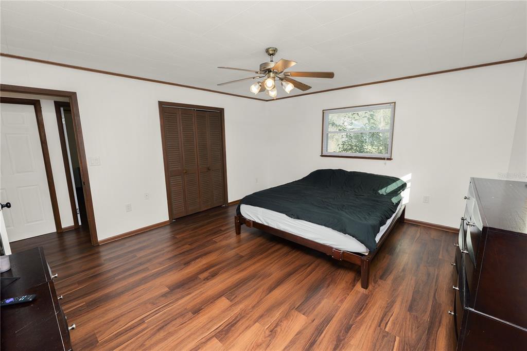 4615 Old Polk City Road Lakeland, FL 33809 - Photo 27 of 71 a bedroom with wooden floor and a ceiling fan