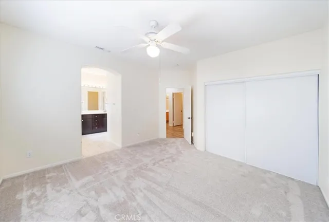 an empty room with fan and entryway