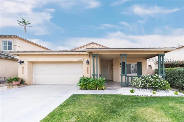a front view of a house with a garden and plants