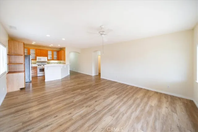 a view of a kitchen with wooden floor and a refrigerator