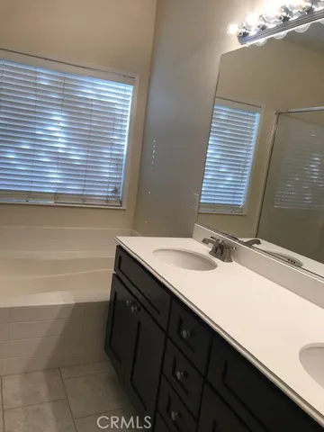 a bathroom with a sink a bathtub and next to a window