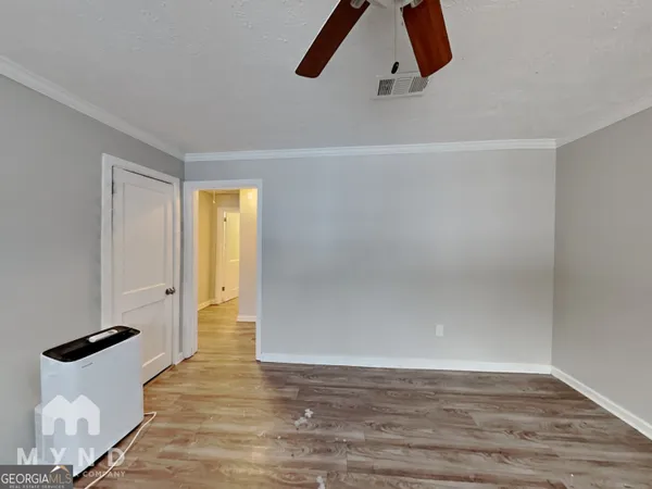 a view of an empty room with wooden floor and cabinet