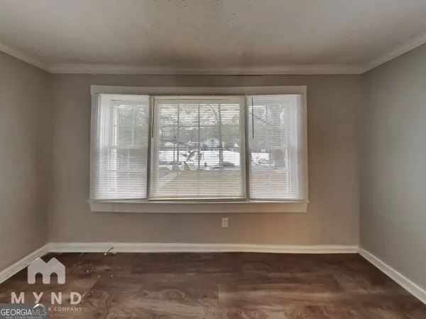 an empty room with wooden floor and a window