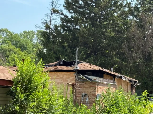 a backyard of a house with lawn chairs and plants