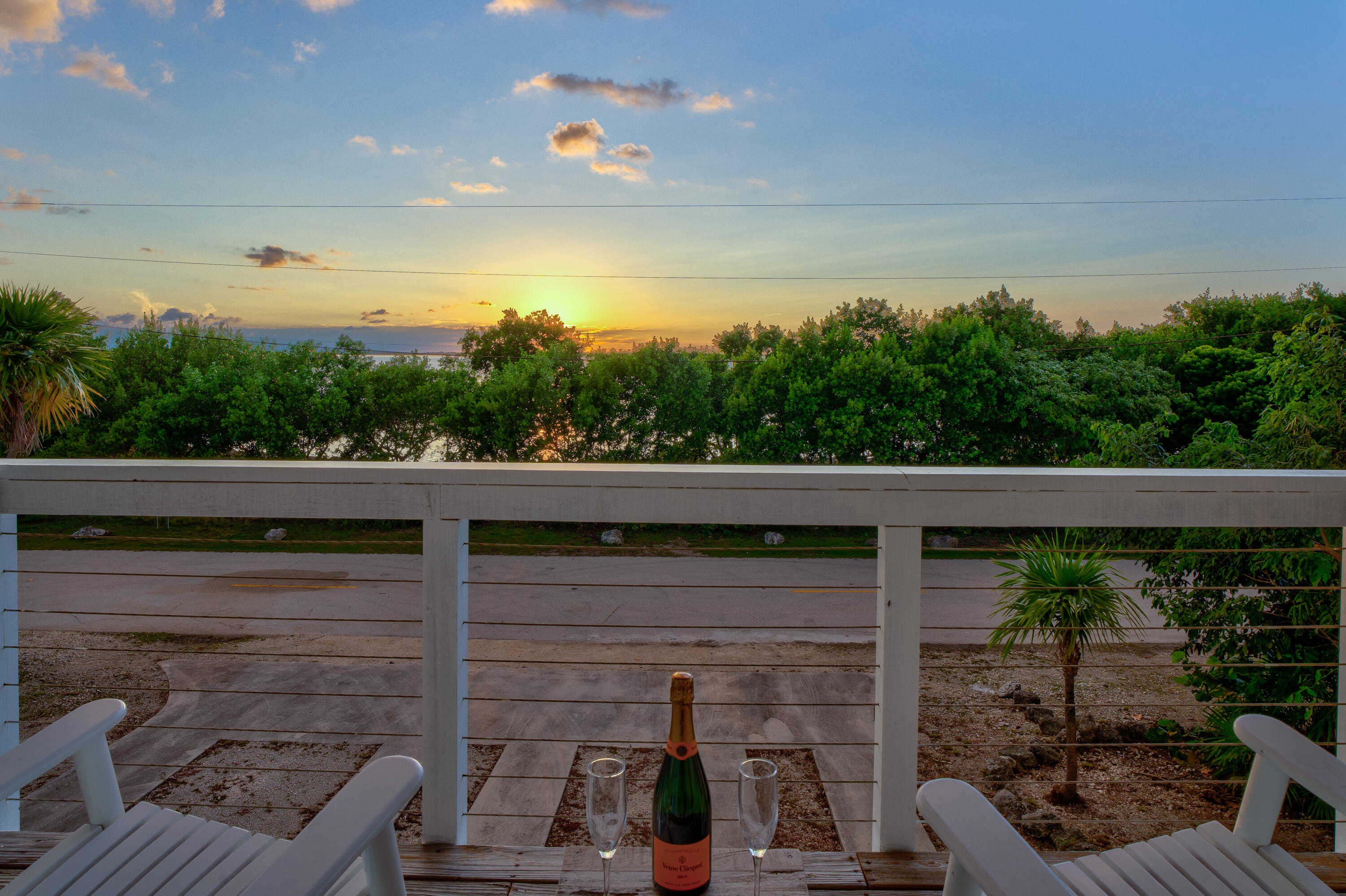 3831 Sunset Drive Big Pine Key, FL 33043 - Photo 52 of 59 a view of a balcony with two chairs and a table