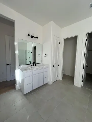 a bathroom with a double vanity sink mirror and tub