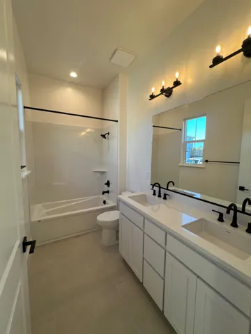 a bathroom with a tub a sink and mirror