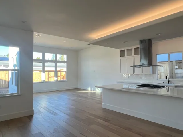 a kitchen with stainless steel appliances granite countertop a sink a stove and a wooden floors