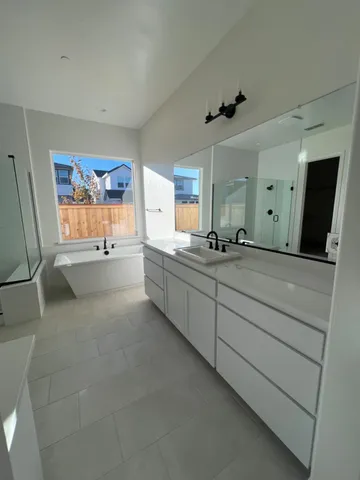 a large bathroom with a large mirror vanity and a bathtub