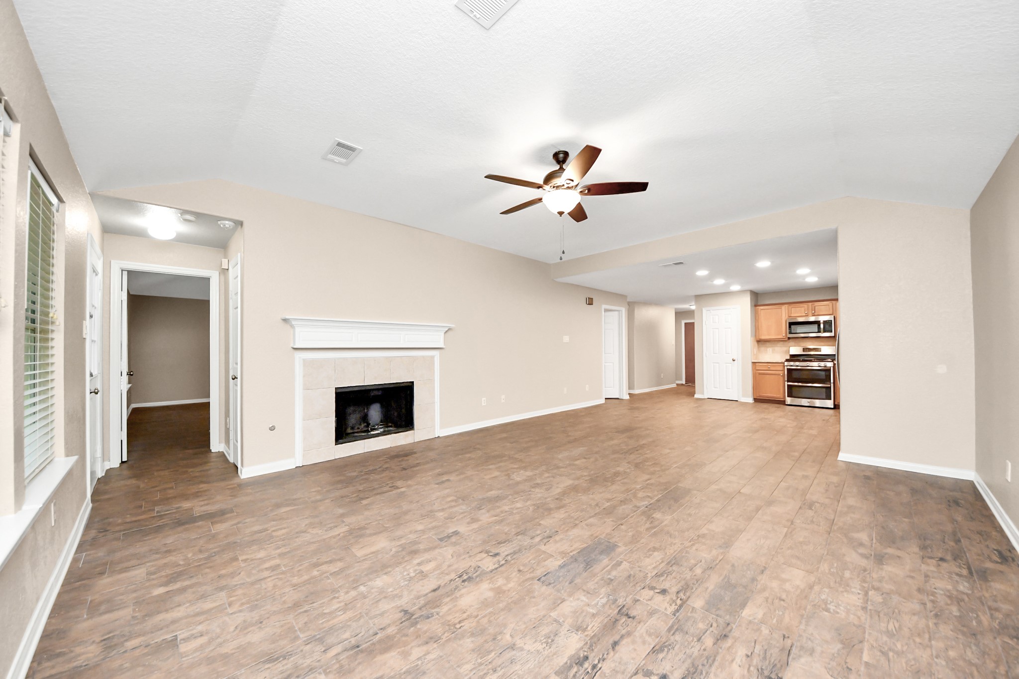 14610 Hazy Ridge Lane Cypress, TX 77429 - Photo 14 of 44 Inviting family room featuring a beautiful fireplace, abundant natural light, and an open layout ideal for everyday living and entertaining.