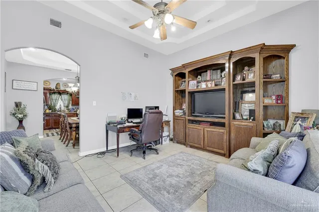 a living room with furniture a flat screen tv and a window