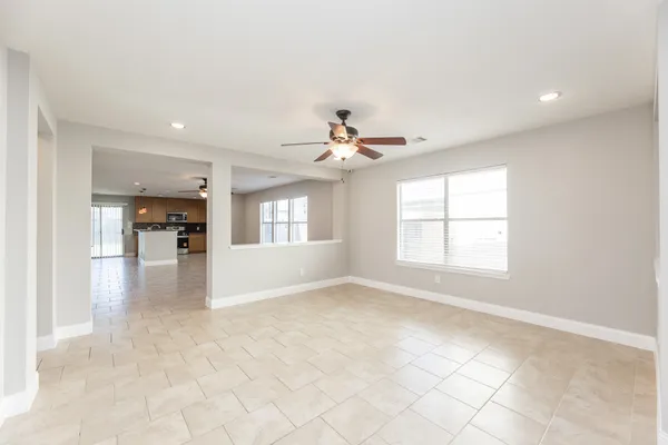 an empty room with chandelier and windows