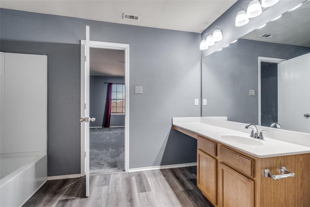 2541 Grand Gulf Road Fort Worth, TX 76123 - Photo 23 of 25 a bathroom with a sink a mirror and a bathtub