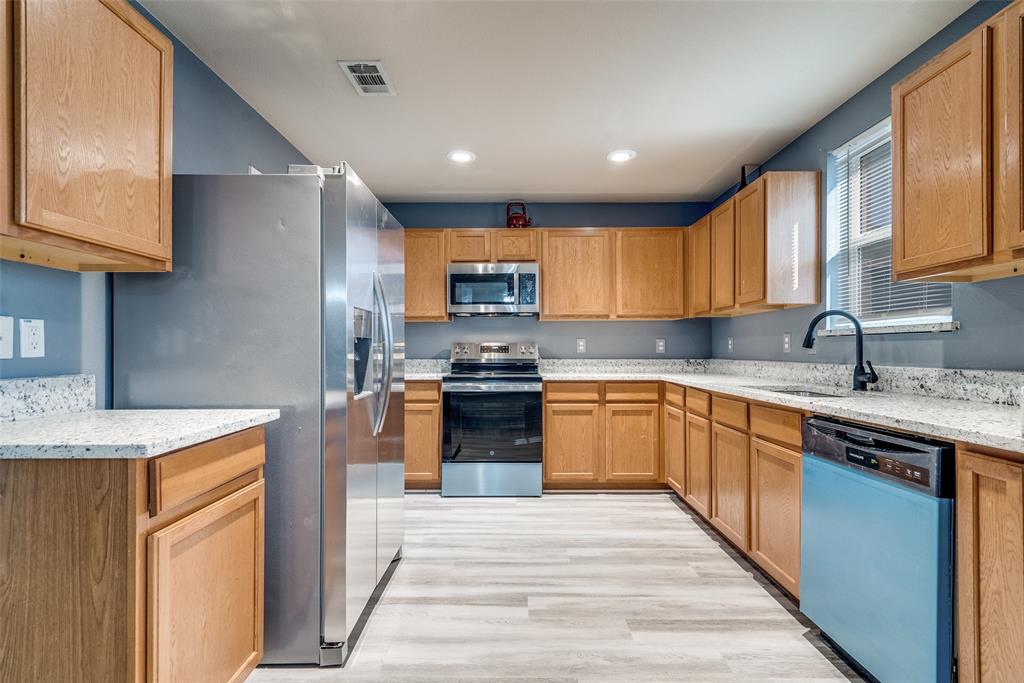 2541 Grand Gulf Road Fort Worth, TX 76123 - Photo 7 of 25 a kitchen with stainless steel appliances granite countertop a sink stove and refrigerator