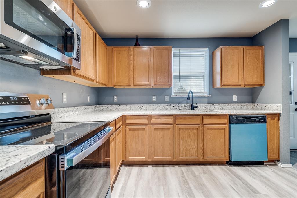 2541 Grand Gulf Road Fort Worth, TX 76123 - Photo 8 of 25 a kitchen with stainless steel appliances granite countertop wooden cabinets a sink and dishwasher