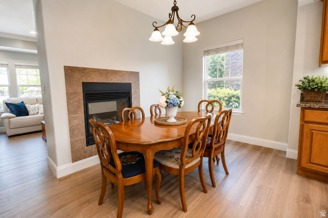 896 Cres Drive South Mapleton, UT 84664 - Photo 6 of 32 Dining area featuring a tiled fireplace and wood-finish flooring
