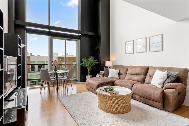 a living room with furniture and a floor to ceiling window