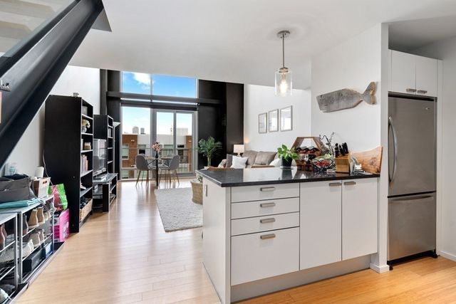 a kitchen with stainless steel appliances granite countertop a refrigerator a stove and a wooden floors