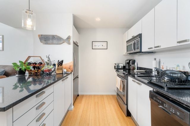 a kitchen with stainless steel appliances granite countertop a sink stove and cabinets