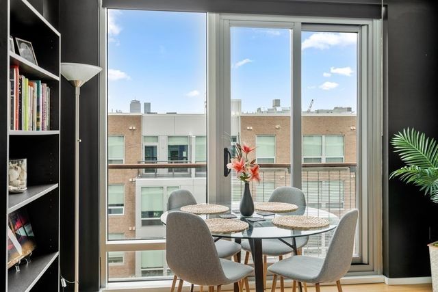 a dining room with furniture water view and a floor to ceiling window