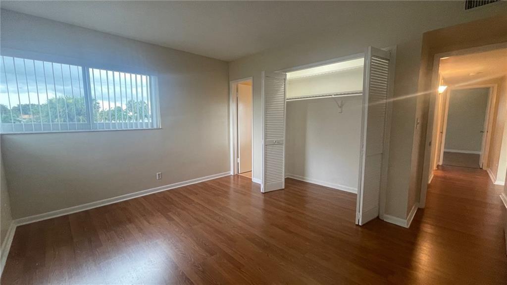 1911 Northeast 28th Court, Unit 2B Lighthouse Point, FL 33064 - Photo 12 of 17 an empty room with wooden floor and windows
