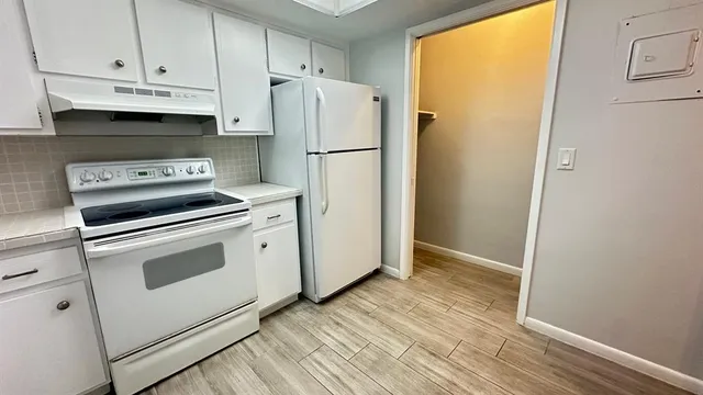 a kitchen with a white cabinets and white appliances