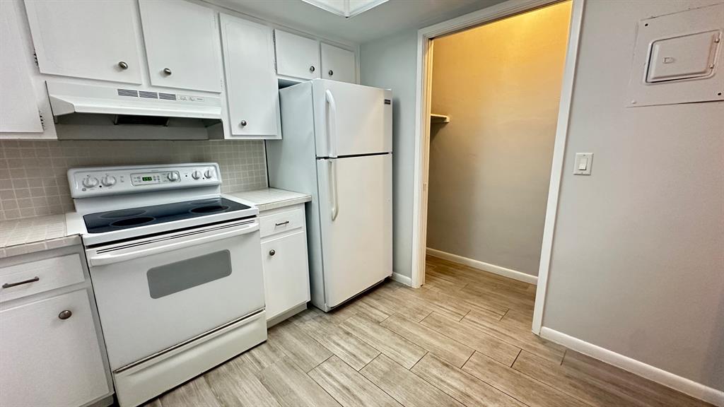 1911 Northeast 28th Court, Unit 2B Lighthouse Point, FL 33064 - Photo 3 of 17 a kitchen with a white cabinets and white appliances