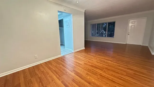 wooden floor in an empty room with a window