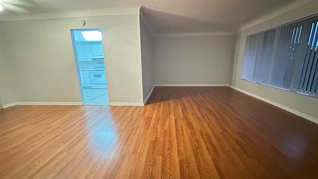 1911 Northeast 28th Court, Unit 2B Lighthouse Point, FL 33064 - Photo 7 of 17 an empty room with wooden floor and windows