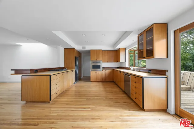 a large kitchen with stainless steel appliances granite countertop a large counter top and a wooden floors