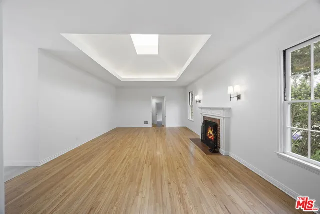 an empty room with windows and fireplace