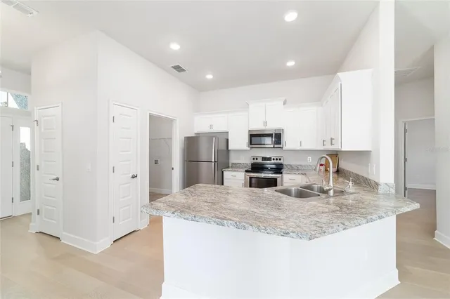 a kitchen with granite countertop a refrigerator and a sink