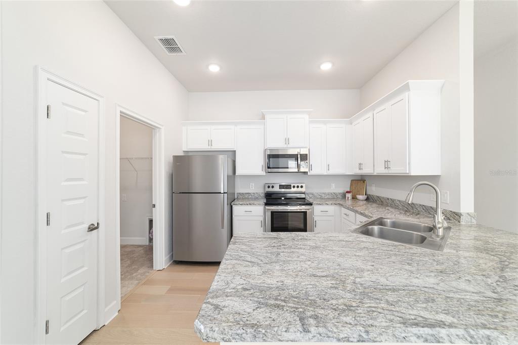 4373 Northeast 31st Street Ocala, FL 34470 - Photo 18 of 51 a kitchen with granite countertop a refrigerator and a sink