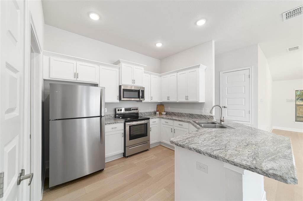 4373 Northeast 31st Street Ocala, FL 34470 - Photo 19 of 51 a kitchen with granite countertop a refrigerator sink stove and oven