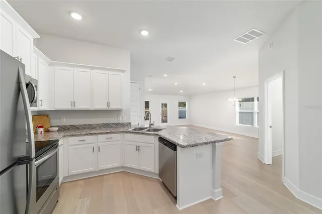 a view of a livingroom with wooden floor and kitchen space