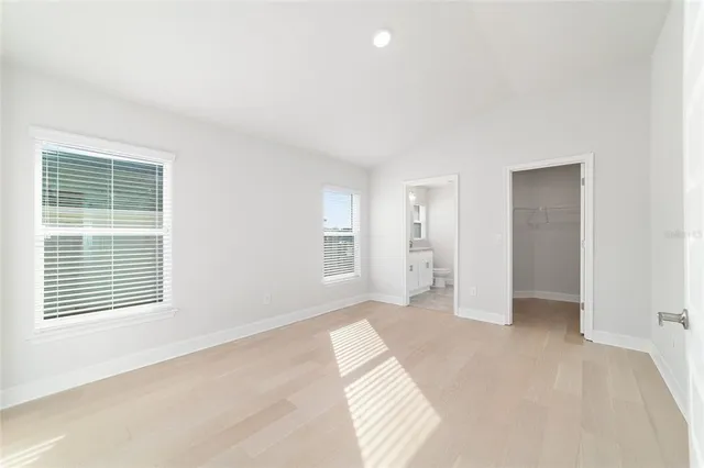 a view of a big room with wooden floor and windows