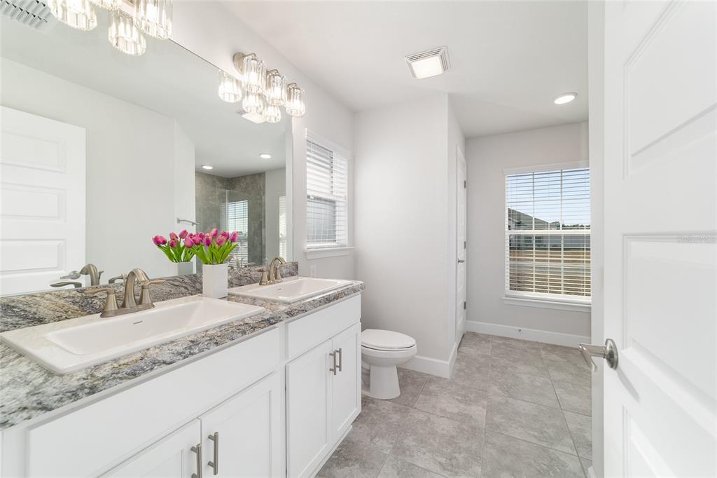 4373 Northeast 31st Street Ocala, FL 34470 - Photo 25 of 51 a bathroom with a granite countertop sink mirror and a toilet