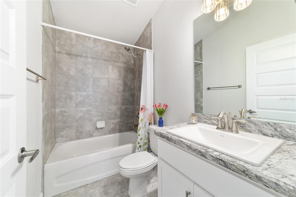 4373 Northeast 31st Street Ocala, FL 34470 - Photo 37 of 51 a bathroom with a granite countertop sink mirror toilet and bathtub