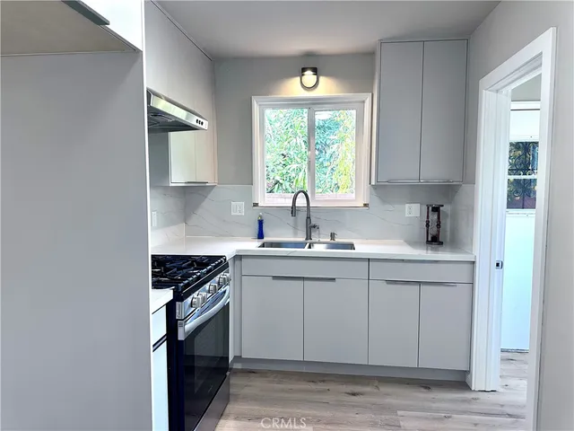 a kitchen with stainless steel appliances granite countertop a sink stove and cabinets