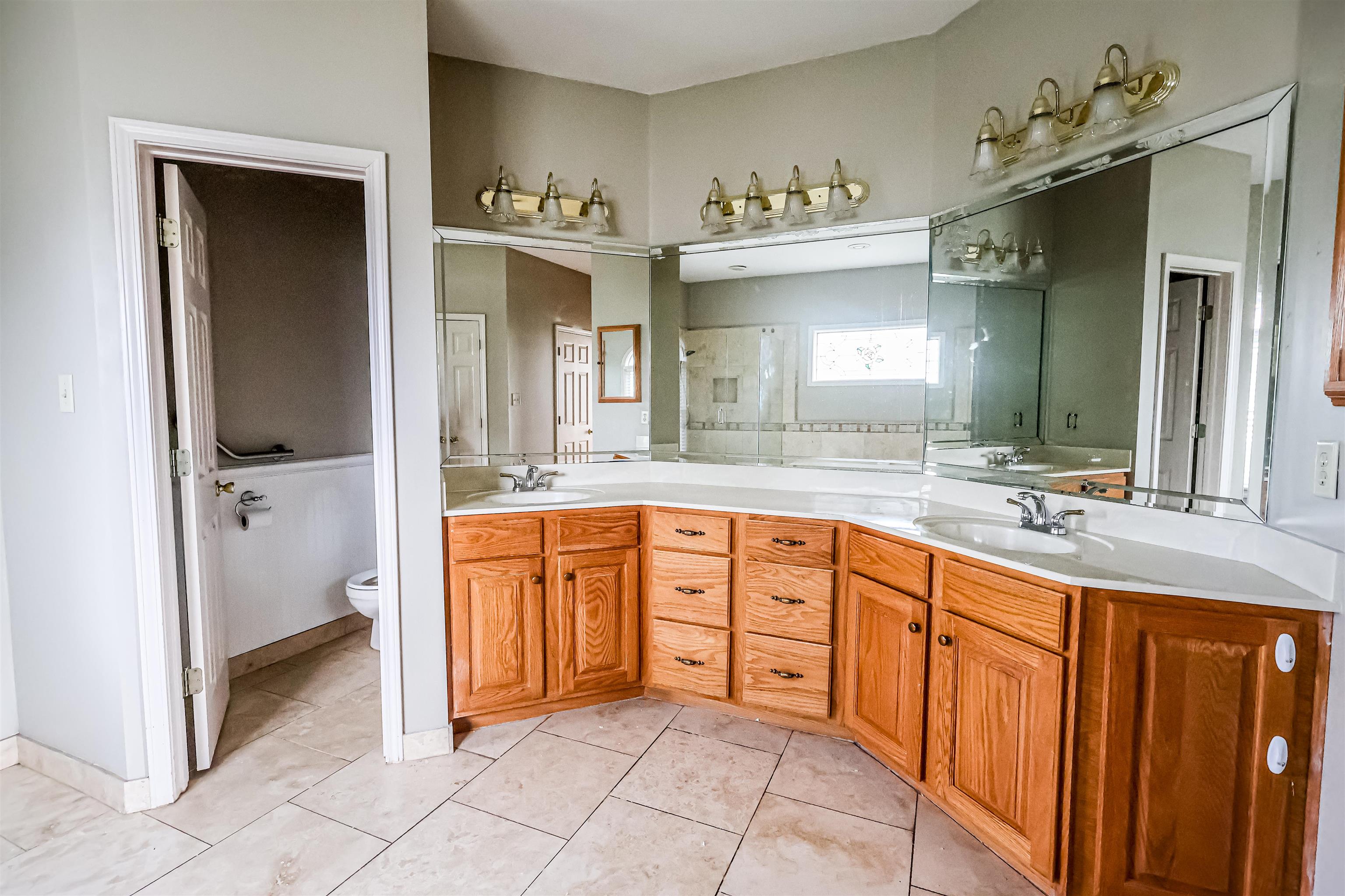 121 Reed Circle Drummonds, TN 38023 - Photo 14 of 38 Full bathroom with toilet, a sink, tile patterned floors, and double vanity